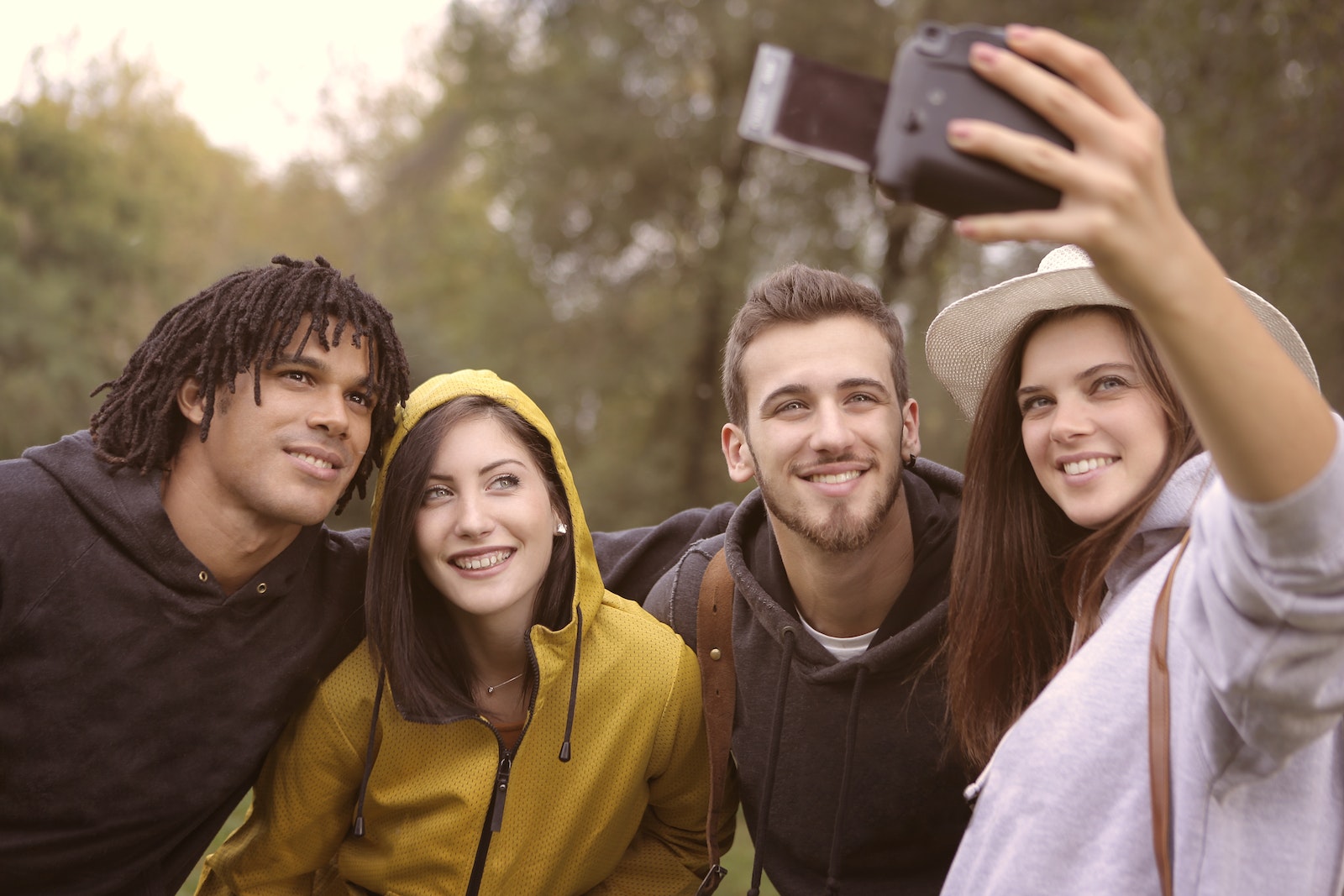 Happy diverse friends taking selfie in park