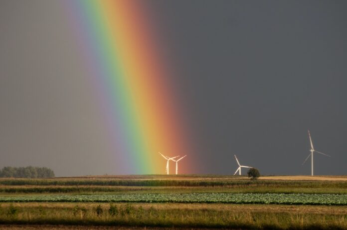 Landscape Photography of Field With Wind Mill With Rainbow