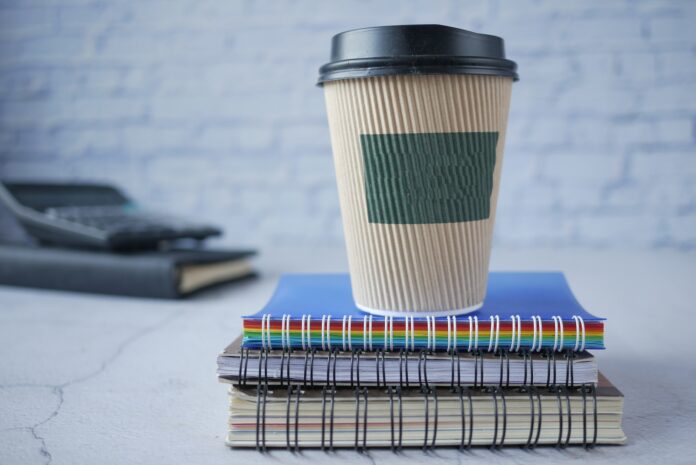 Disposable Cup on Top of Spiral Notebooks